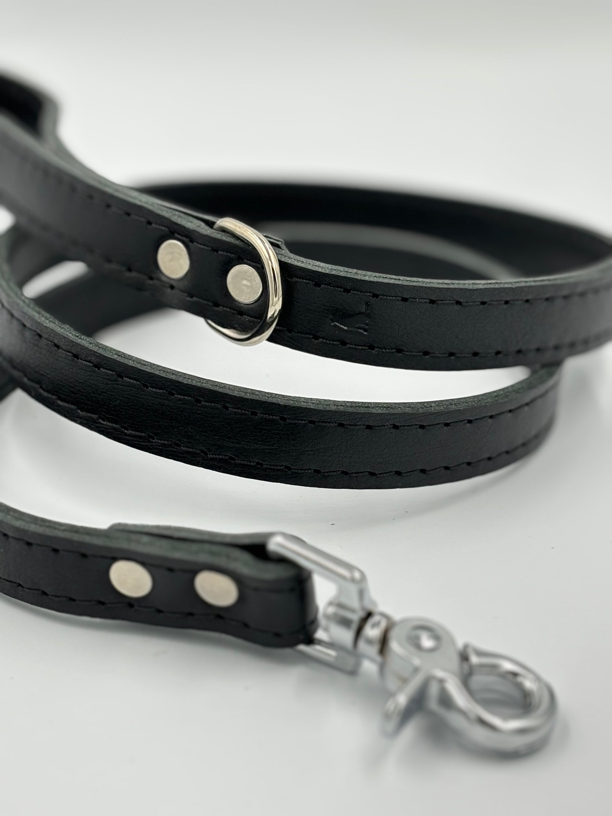 Luxurious black leather dog leash with silver hardware, showcasing exceptional craftsmanship and refined elegance.